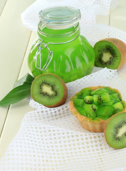 Jar of jam kiwi on wooden table on natural background — Stock Photo, Image