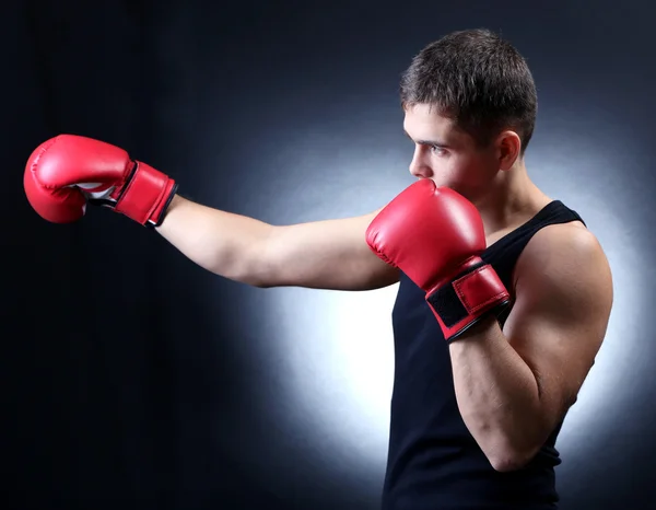 Knappe jonge gespierde bokser op donkere achtergrond — Stockfoto