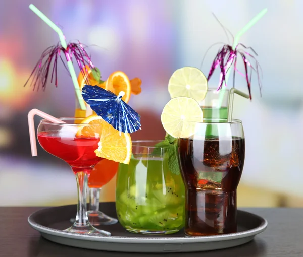 Set of different drinks on tray, on bright background — Stock Photo, Image