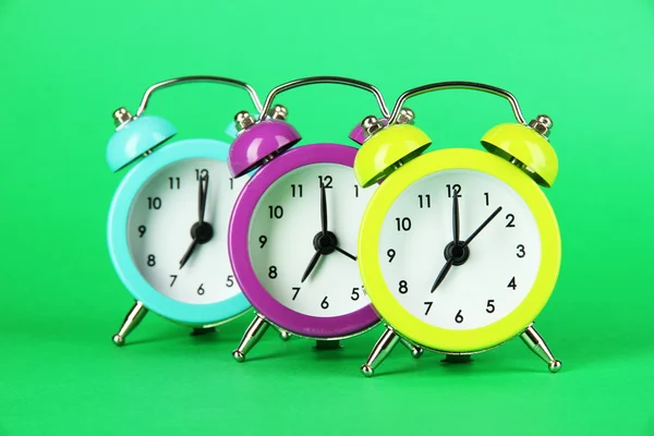 Colorful alarm clock on green background — Stock Photo, Image