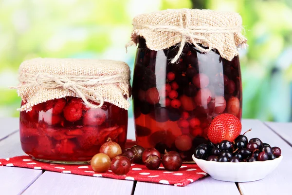 Marmellata di bacche fatta in casa su tavolo di legno su sfondo luminoso — Foto Stock