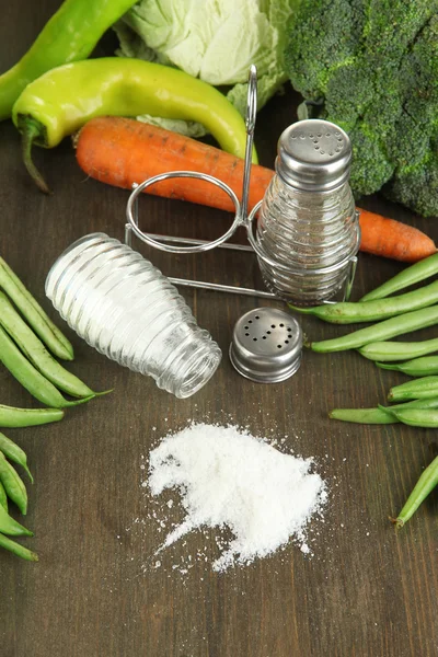 Composición de molinos de sal y pimienta y verduras frescas, sobre fondo de madera — Foto de Stock