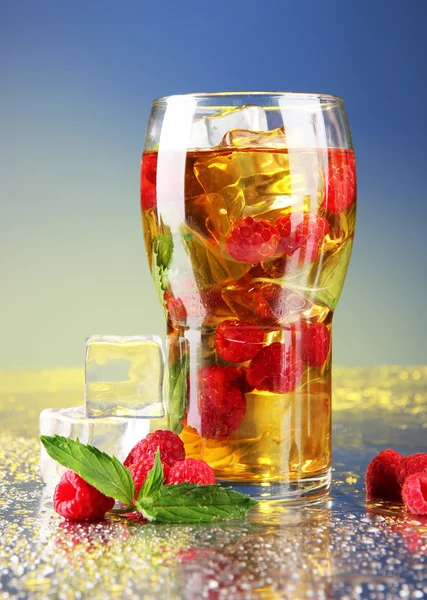 Iced tea with raspberries and mint on blue background — Stock Photo, Image