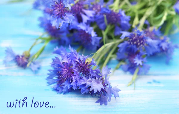 Beautiful bouquet of cornflowers on blue wooden background — Stock Photo, Image