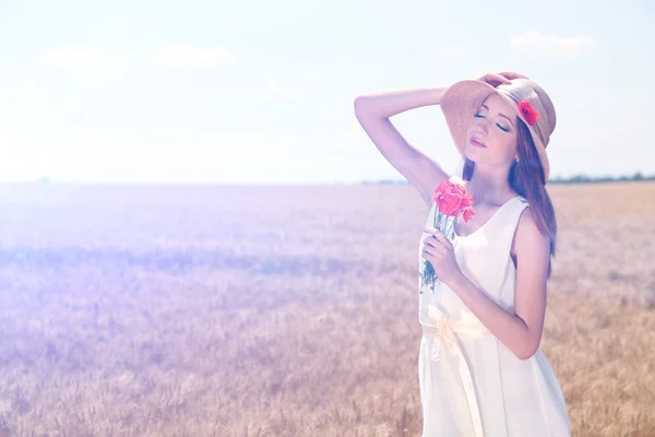 Portret van mooie jonge vrouw met papavers op het gebied — Stockfoto