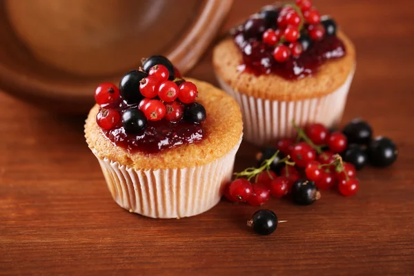 Tasty muffins with berries on wooden background — Stock Photo, Image