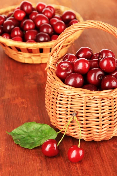 Cherry berries in wicker baskets on wooden table close-up — Stock Photo, Image