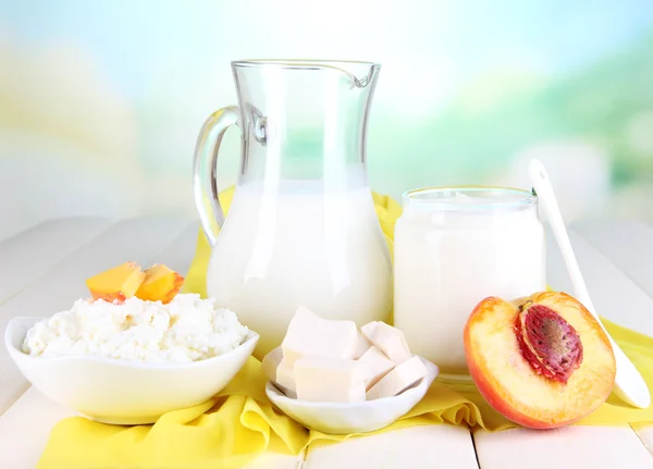 Productos lácteos frescos con melocotones sobre mesa de madera sobre fondo natural —  Fotos de Stock