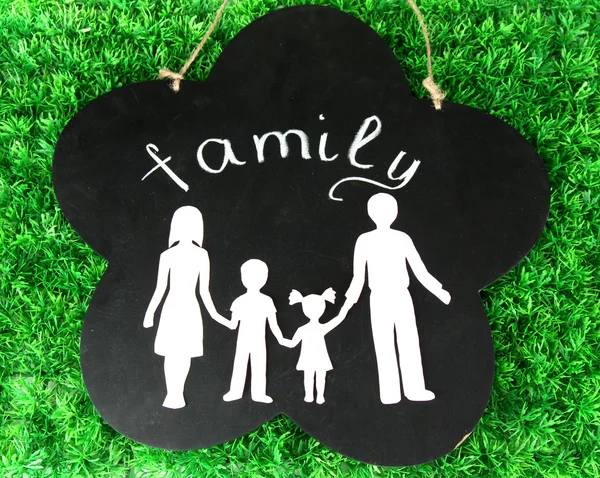 Family from paper on wooden board on bright background — Stock Photo, Image