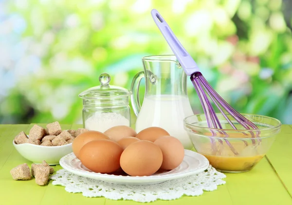 Ingredients for dough on wooden table on natural background — Stock Photo, Image