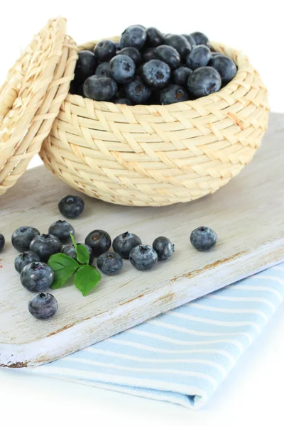 Blueberries in wooden basket on board on napkin isolated on white — Stock Photo, Image