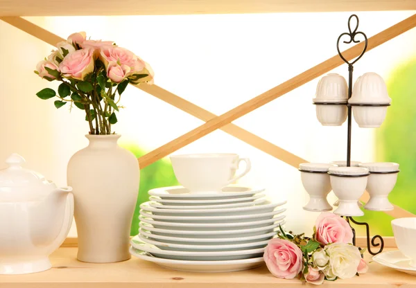 Lots beautiful dishes on wooden shelf on natural background — Stock Photo, Image