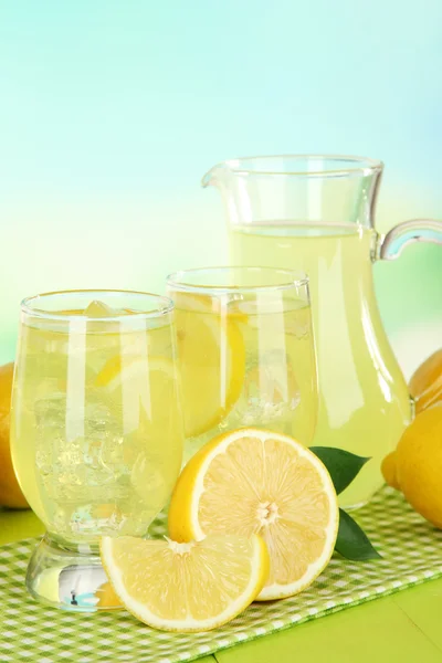 Вкусный лимонад на столе на голубом фоне — стоковое фото