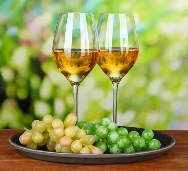 Reife Trauben und Weingläser, auf hellem Hintergrund — Stockfoto
