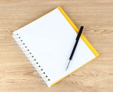 defter ve kalem ahşap masaya