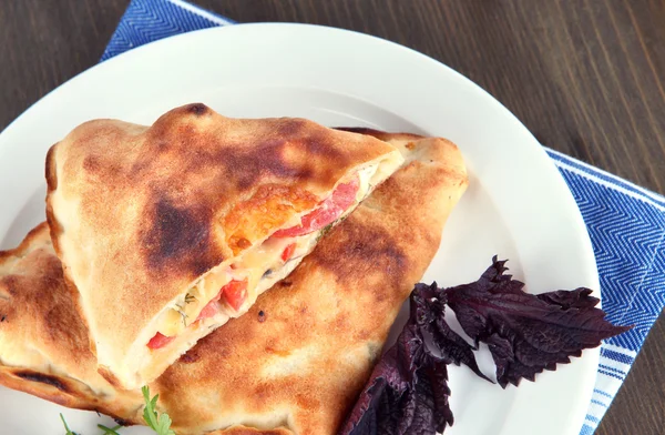 Pizza calzone peçete ahşap masa üzerinde plaka üzerinde