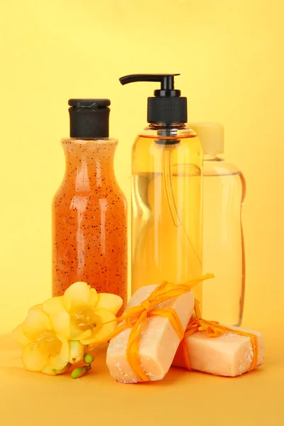 Liquid and hand-made soaps on yellow background — Stock Photo, Image