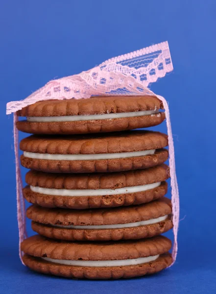 Chocolate cookies with creamy layer on blue background — Stock Photo, Image