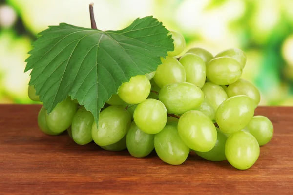 Uvas maduras deliciosas en la mesa sobre fondo brillante —  Fotos de Stock