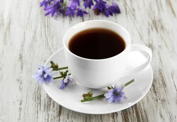 Cup of tea with chicory, on wooden background — Stock Photo, Image