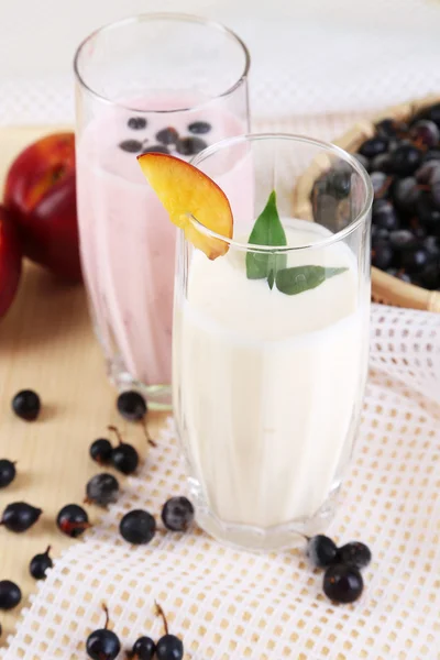 Delicious milk shakes with blackberry and peach on wooden table close-up — Stock Photo, Image