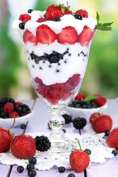 Přírodní jogurt s čerstvým ovocem na dřevěný stůl na zeleném pozadí — Stock fotografie
