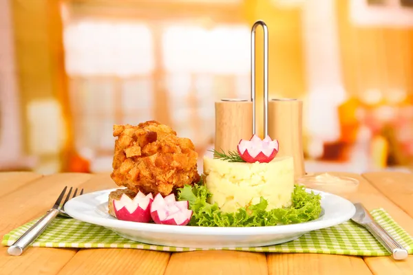 Chicken Kiev on croutons with mashed potatoes, on wooden table, on bright background — Stock Photo, Image