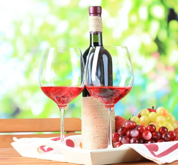 Copos de vinho no guardanapo na bandeja na mesa de madeira no fundo da natureza — Fotografia de Stock