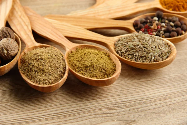 Assortimento di spezie in cucchiai di legno su fondo di legno — Foto Stock