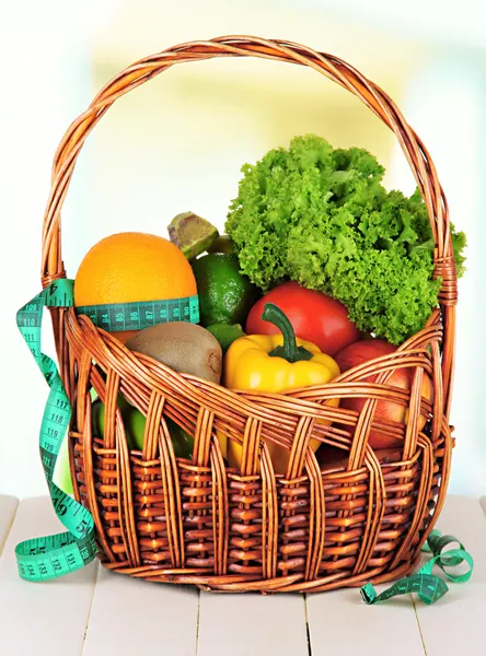 Fresh vegetables in wicker basket on table on light background — Stock Photo, Image