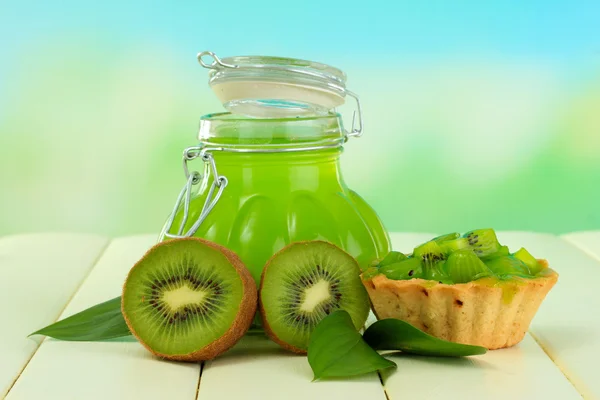 Jar of jam kiwi on wooden table on natural background — Stock Photo, Image