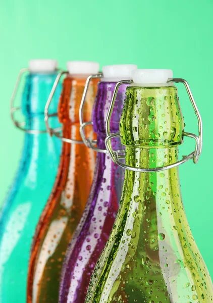 Colorful bottles on green background — Stock Photo, Image