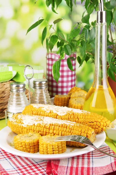 O smaku gotowanej kukurydzy na tabliczce na drewnianym stole na naturalne tło — Zdjęcie stockowe