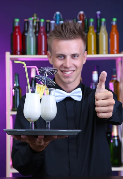 Porträtt av stilig bartender med pina colada cocktail, bar — Stockfoto