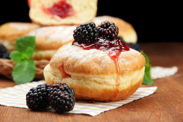 Leckere Donuts mit Beeren auf Holztisch — Stockfoto