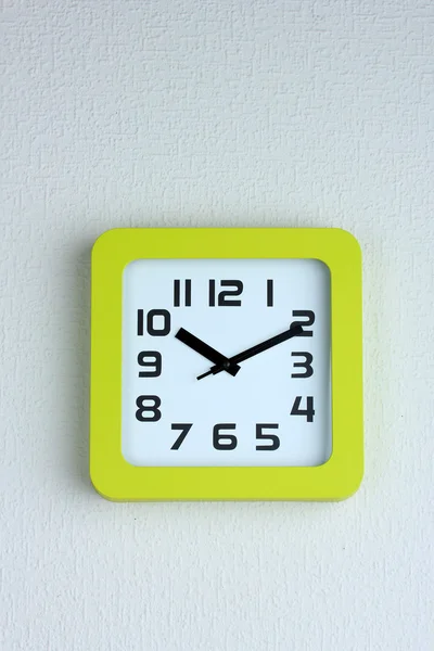 Office clock on color wall background — Stock Photo, Image