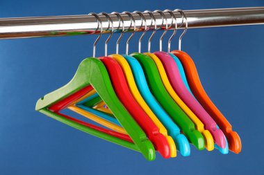 mavi arka plan üzerinde renkli elbise askıları