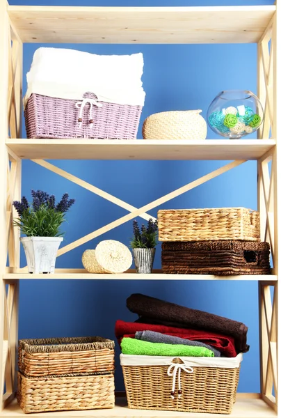 Hermosos estantes blancos con diferentes objetos relacionados con el hogar, en el fondo de la pared de color —  Fotos de Stock