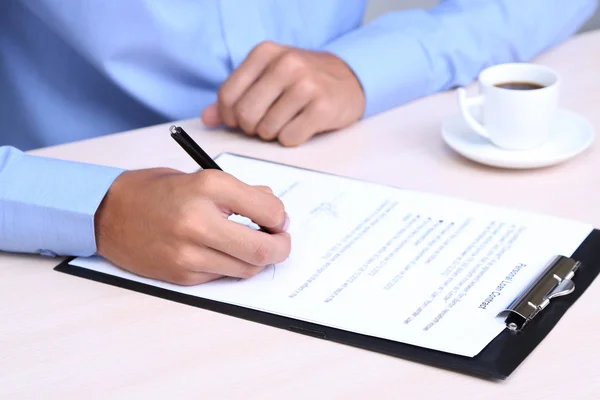 Empresário escrevendo no documento em close-up escritório — Fotografia de Stock