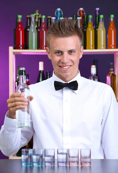 Bartender is pouring vodka into glasses — Stock Photo, Image
