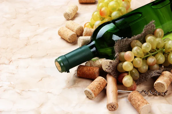 Flaska vin, druvor och korkar på gamla papper bakgrund — Stockfoto