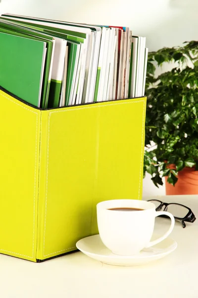 Tidskrifter och mappar i gröna lådan, på kontor interiör bakgrund — Stockfoto