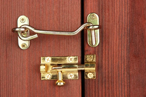 Metal hook and deadbolt in wooden door close-up — Stock Photo, Image