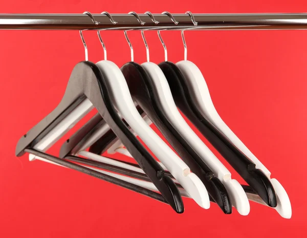 Cabides de roupas preto e branco no fundo de cor — Fotografia de Stock