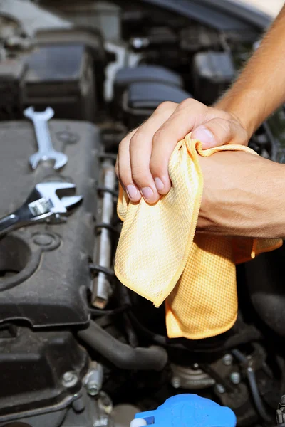 Mecânico do motor limpando suas mãos gordurosas após a manutenção do carro — Fotografia de Stock