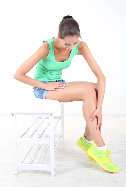 Chica con el pie dolorido aislado en blanco — Foto de Stock