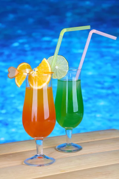 Tasty cocktails on swimming pool background — Stock Photo, Image