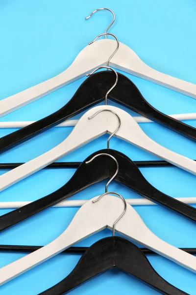 Black and white clothes hangers on color background — Stock Photo, Image