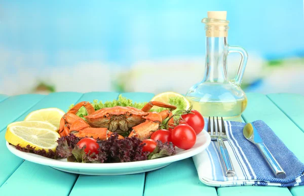 Boiled crab on white plate with salad leaves and tomatoes,on wooden table, on bright background — Stock Photo, Image