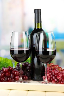 olgunlaşmış üzümler, şişe ve kadeh şarap parlak zemin üzerine tepsi